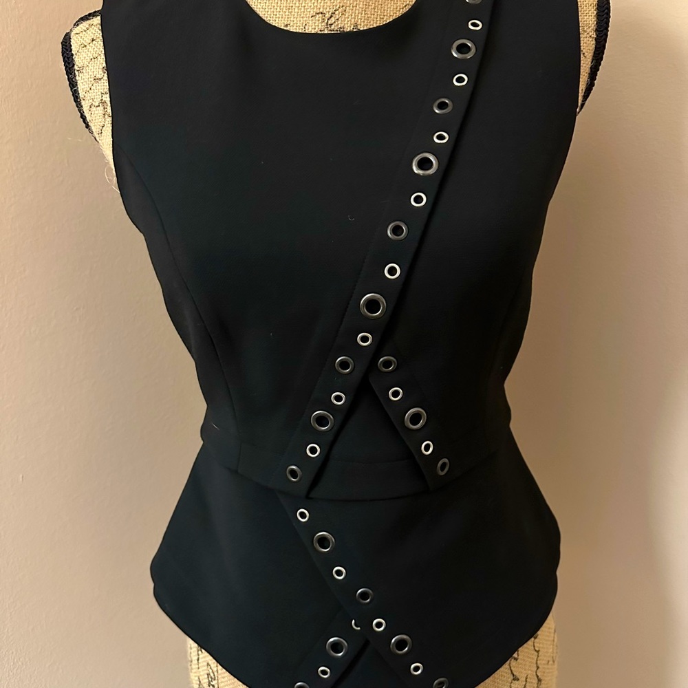 BCBG sleeveless black dress top with peplum and chrome grommet detail.